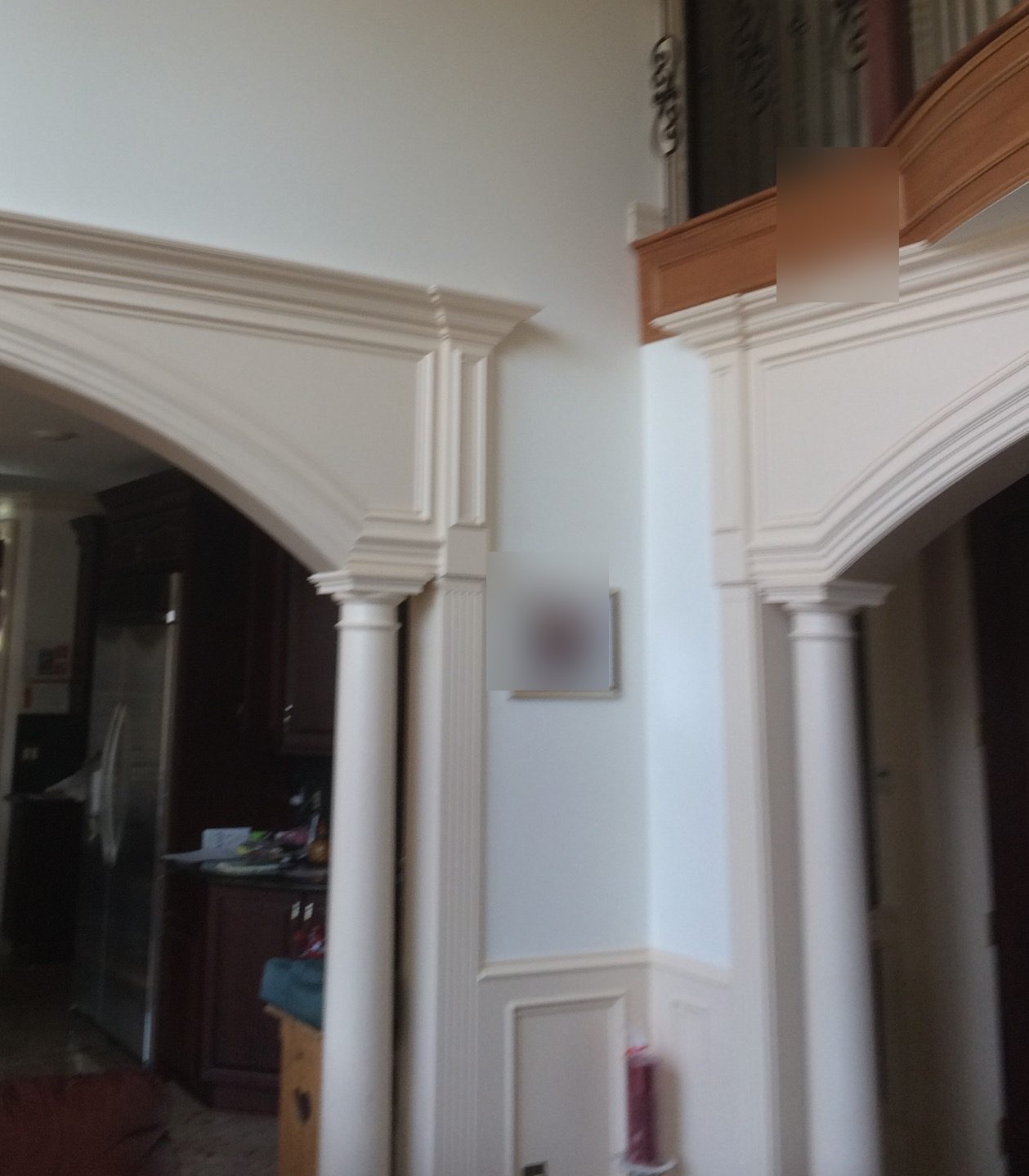 Two painted arched openings on round columns, with fluted pilasters and crown along the tops of the arches.